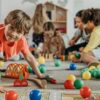 Children playing with colorful educational and sensory toys in a classroom setting, representing inclusive and engaging toys for kids with autism in Pakistan