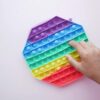 Child playing with a colorful pop-it fidget toy – a popular sensory toy for autism in Pakistan that enhances tactile stimulation and focus.