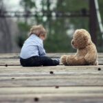 image of a child sitting on road playing with Stuffed Toys in Pakistan